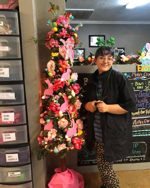 A groomer beside the Valentine tree decorated in pink flowers